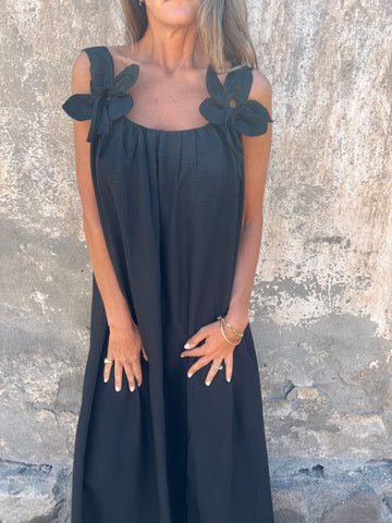 Detailed view of the stylish U-neckline on an elegant women's maxi dress with delicate bow straps.