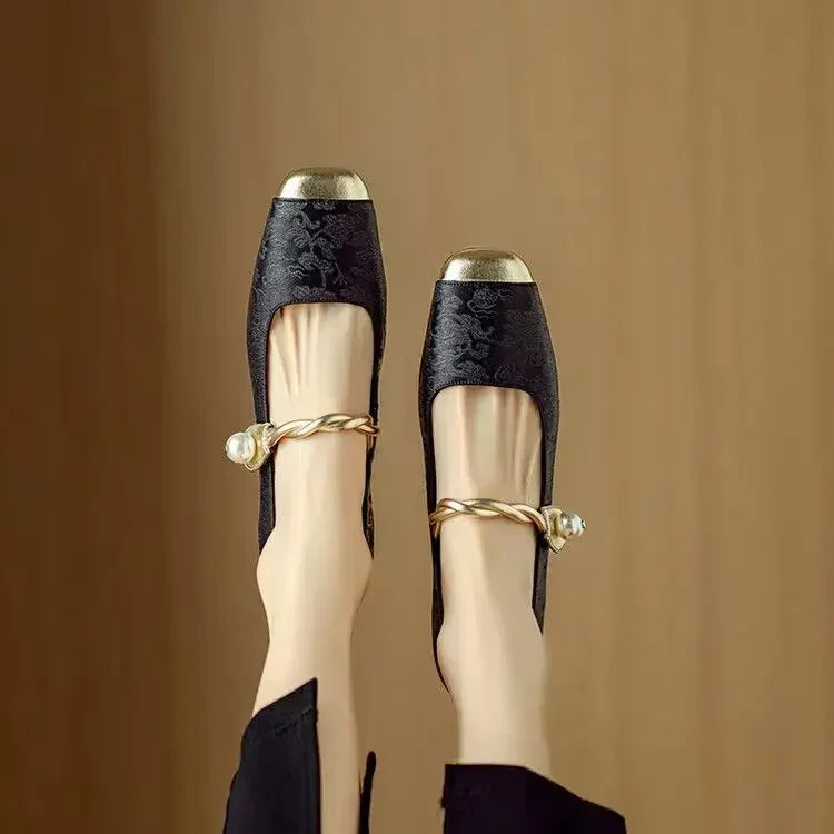 Close-up of the pearl strap detail on women's elegant vintage Mary Jane footwear.