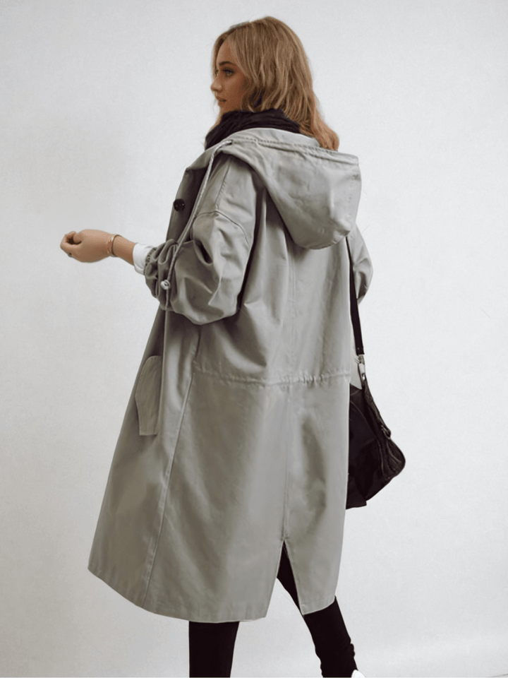 Woman in a chic water-repellent trench coat, a versatile and elegant transitional jacket for women's fashion.