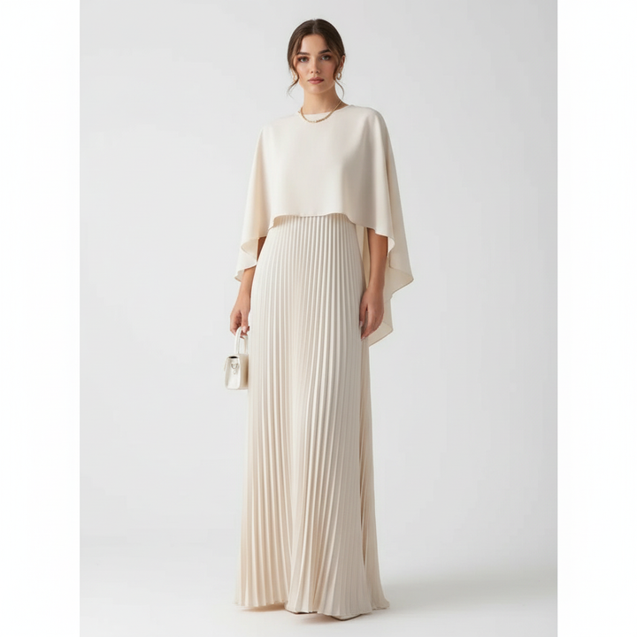 Elegant women's wedding guest maxi dress with flowing pleated skirt and cape overlay.