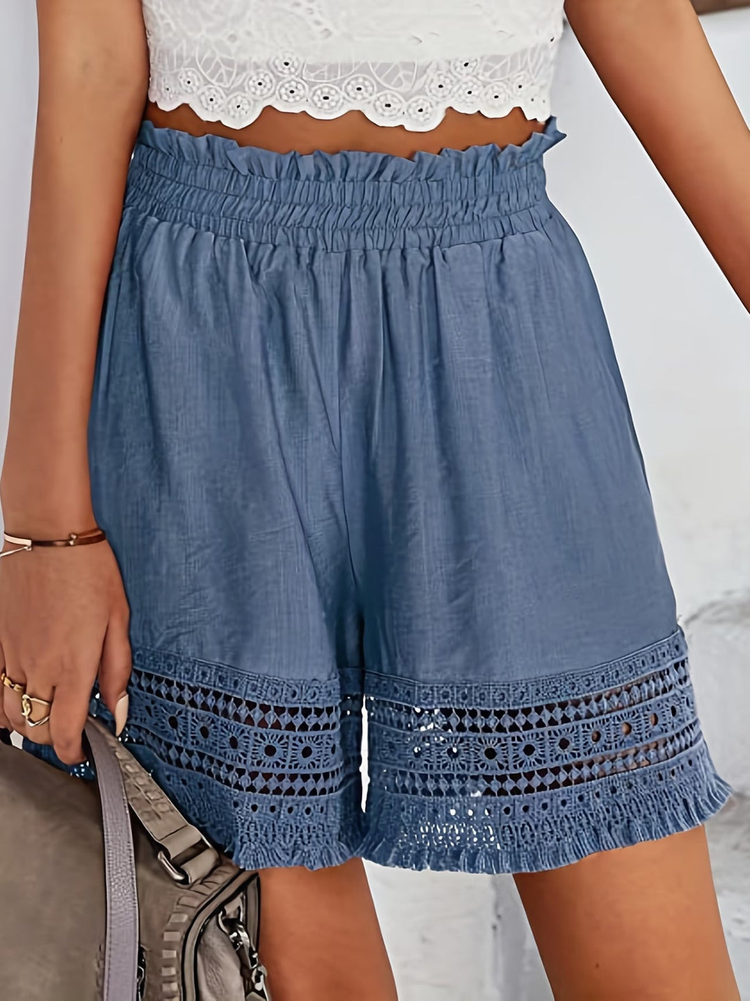 Close-up of women's sophisticated lace trim shorts featuring practical slant pockets. Great for casual elegance.