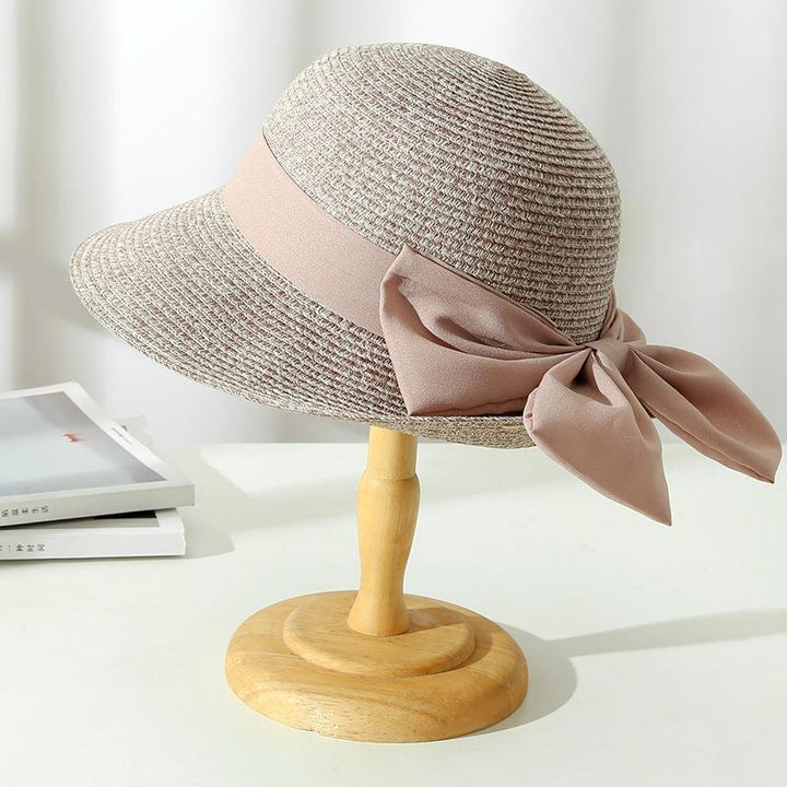 Chic women's wide brim straw sun hat for summer fashion, offering elegant sun protection.