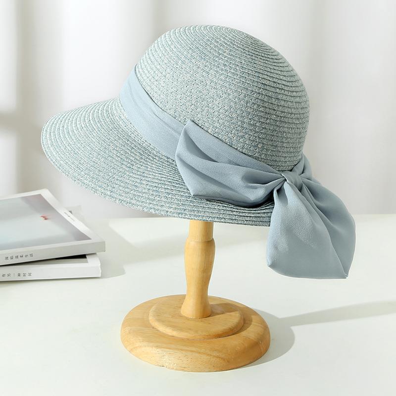 Women's wide brim straw sun hat with a decorative bow, great for garden wear & summer elegance.