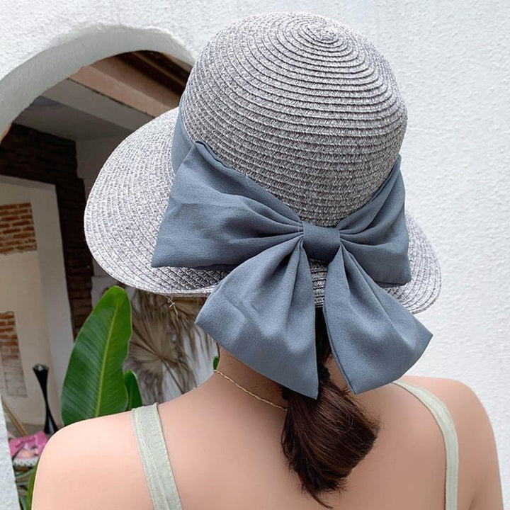 Elegant women's straw wide brim hat for summer, a fashionable sun protection accessory.