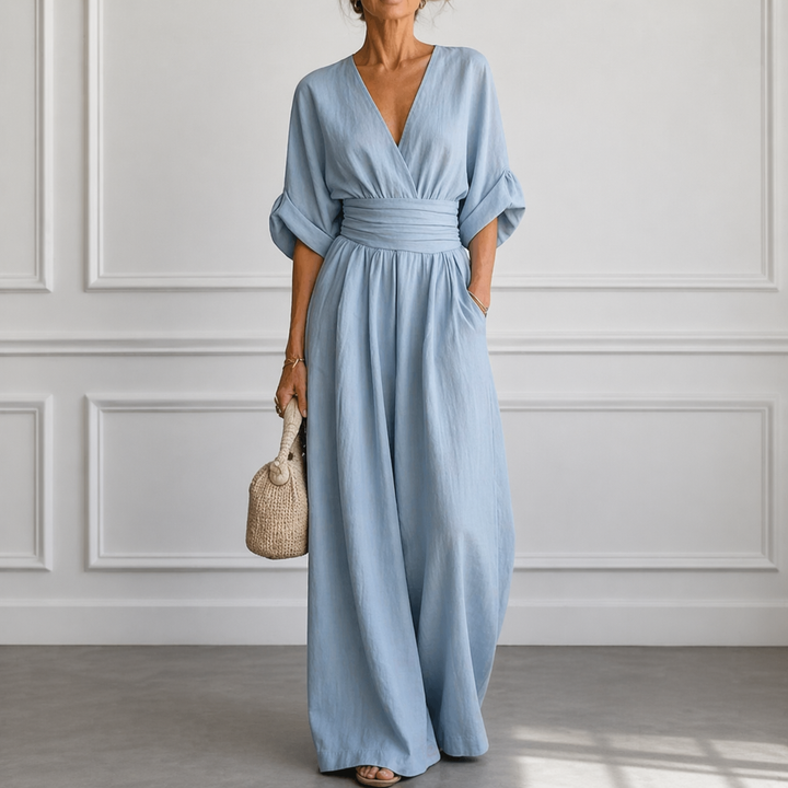 Woman wearing an elegant wide-sleeve V-neck jumpsuit, showcasing its modern design and comfortable silhouette.