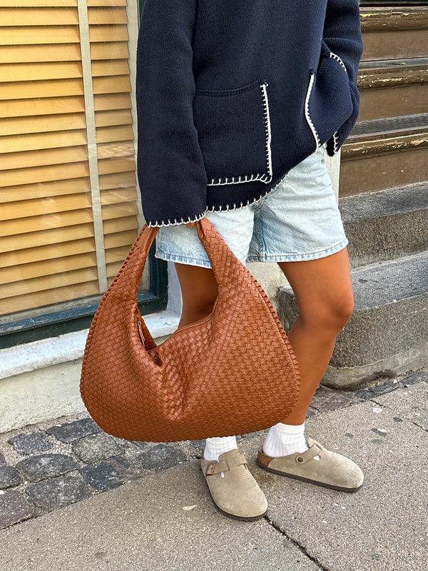 Descriptive image of a women's woven shoulder bag, soft vegan leather, slouch design. Perfect for everyday elegance.