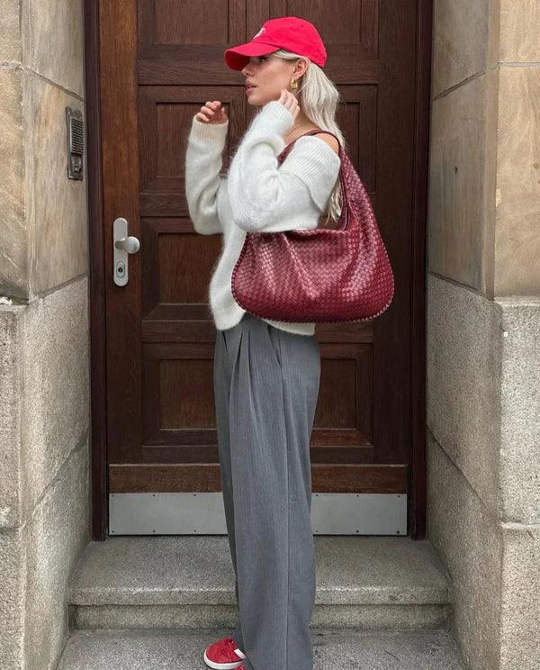 Chic women's woven shoulder bag made from soft vegan leather, featuring a trendy slouch design. Elegant accessory.