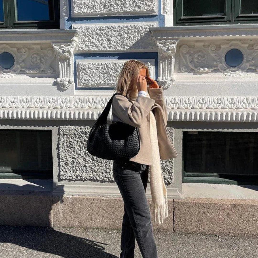 Versatile women's everyday shoulder bag, a soft vegan leather woven design with a sophisticated slouch. Modern handbag.