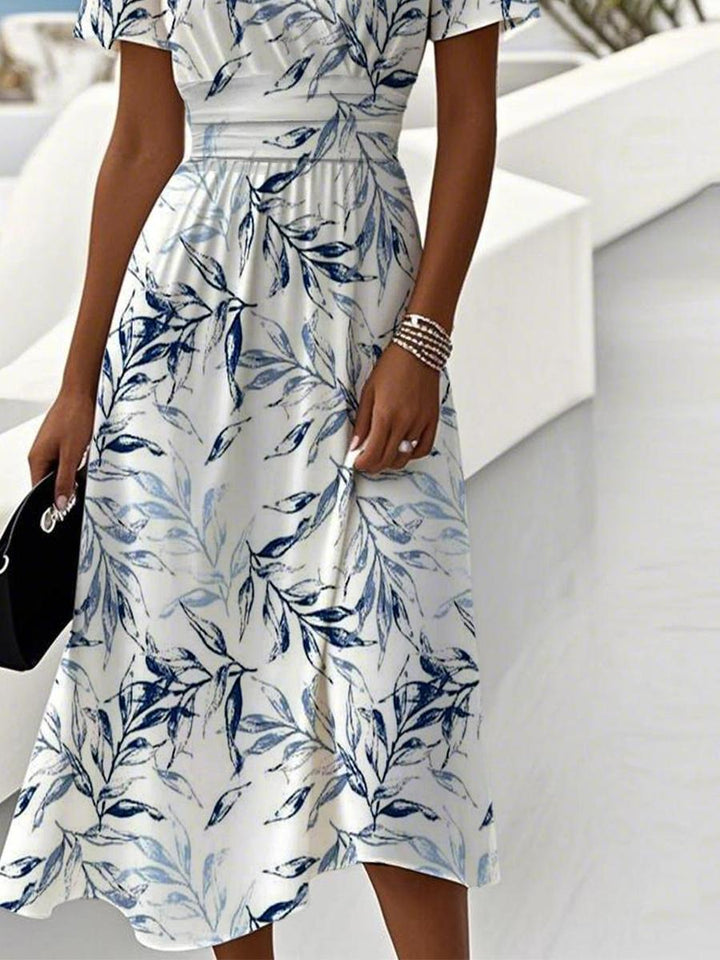 Chic women's short sleeve V-neck wrap midi dress featuring an elegant leaf print. A versatile summer fashion choice.