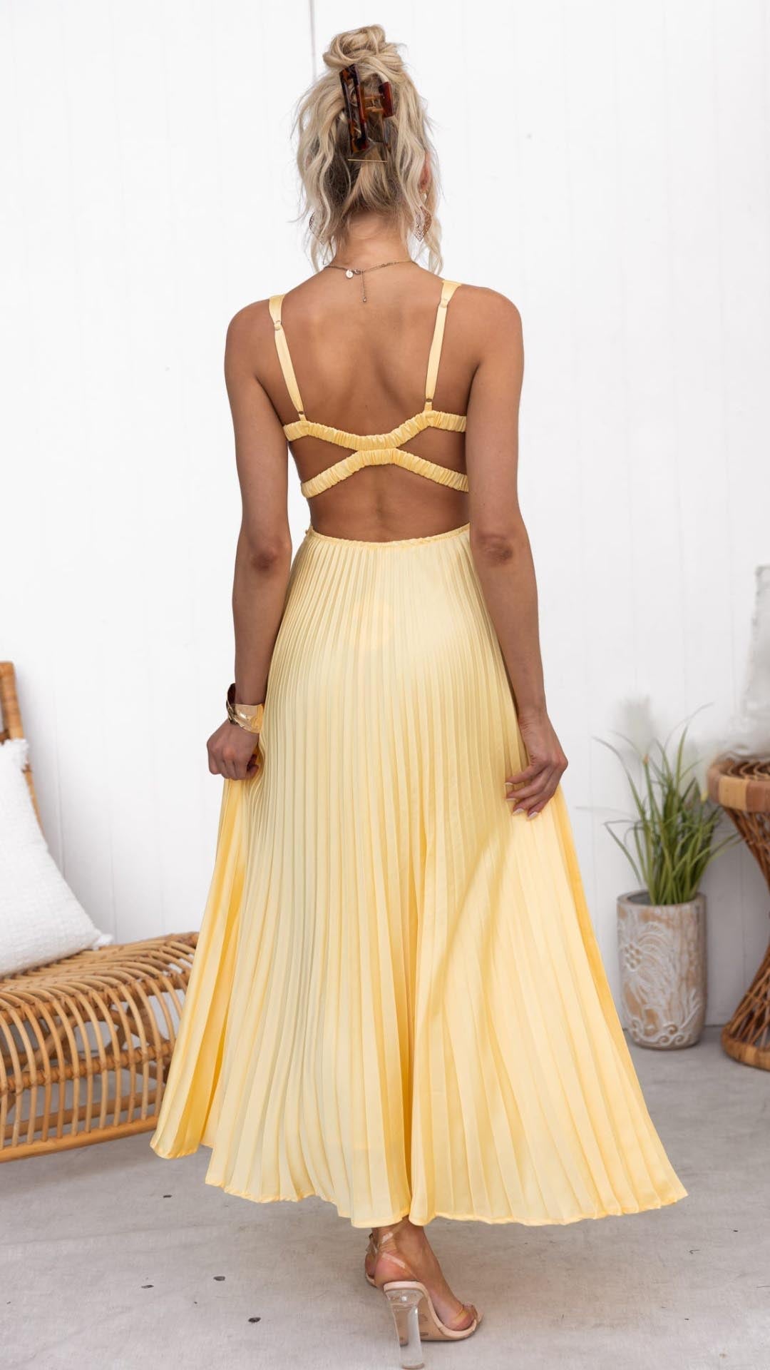 Stylish yellow sleeveless V-neck maxi dress with elegant pleats, open back, and A-line cut for formal occasions.