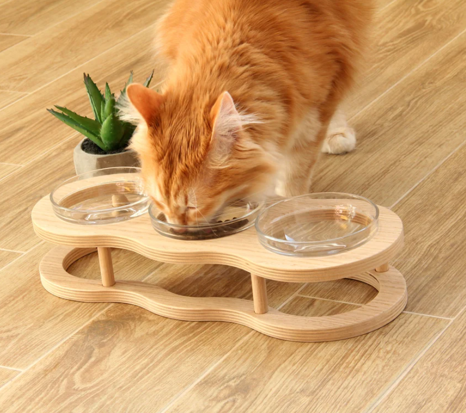Elevated wood pet feeder with two glass bowls & non-slip base for comfortable dog & cat feeding.