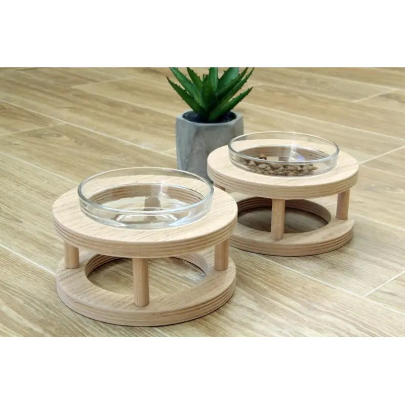 Stylish elevated wood pet feeder with clear glass bowls & non-slip feet, designed for easy pet meals.