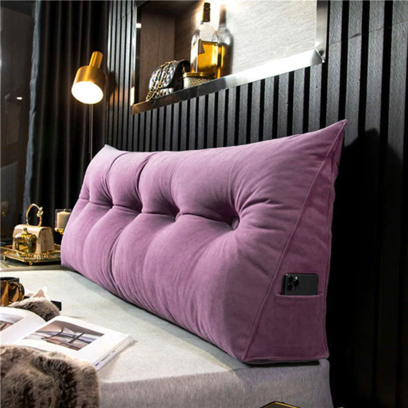 Relaxing on a bed with a versatile ergonomic bed wedge pillow, offering superior lumbar support & comfort.