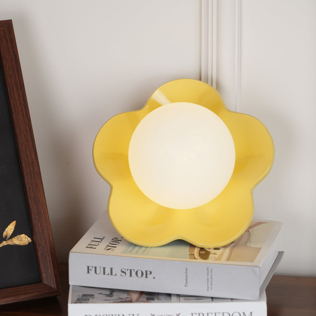 Warm glow from a floral resin & glass indoor wall/ceiling lamp.
