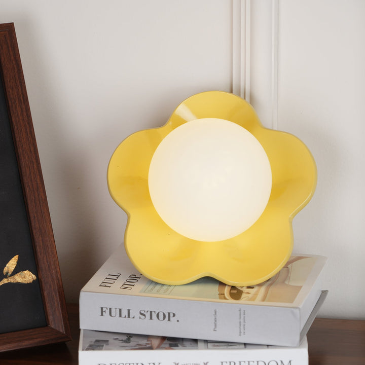 Warm glow from a floral resin & glass indoor wall/ceiling lamp.