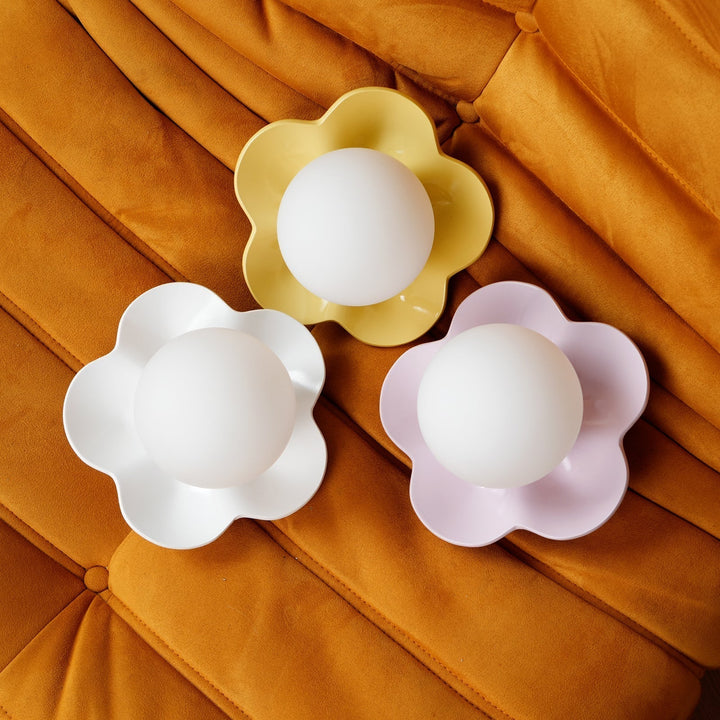 Floral motif resin wall or ceiling light with an elegant glass diffuser.