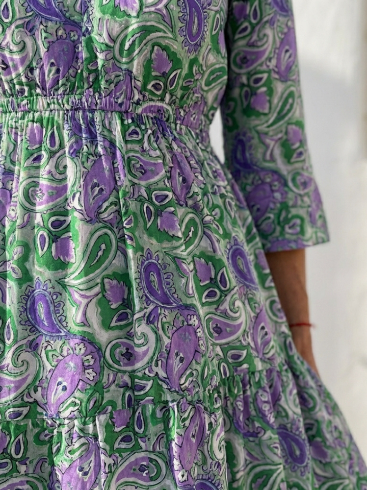 Full-length view of a women's flowy V-neck bohemian maxi dress with long sleeves and detailed paisley print.