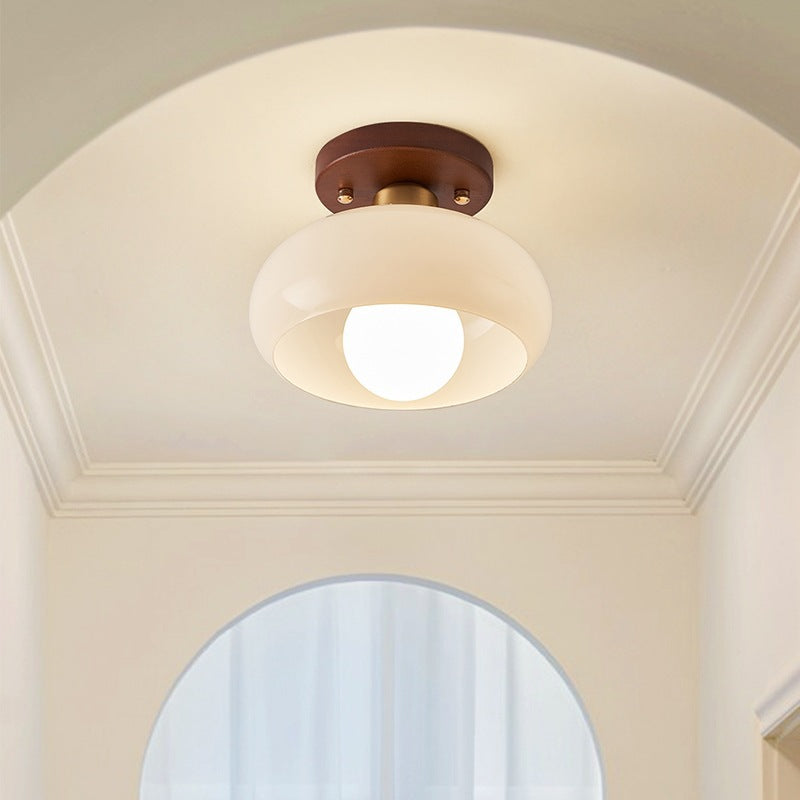 Modern circular ceiling light featuring Bauhaus design and natural wood detail, perfect for living rooms.