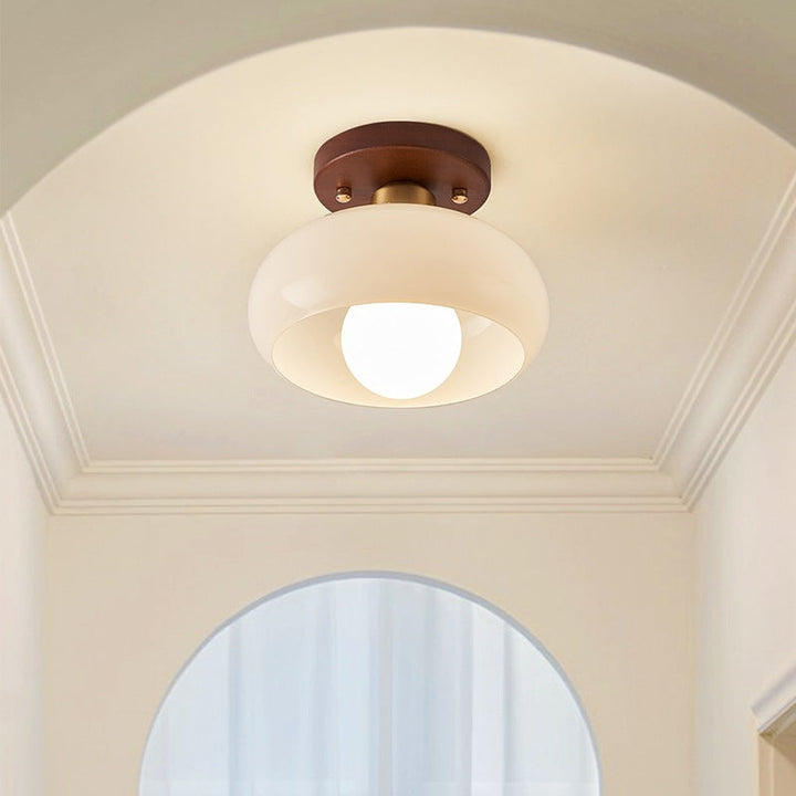 Modern circular ceiling light featuring Bauhaus design and natural wood detail, perfect for living rooms.