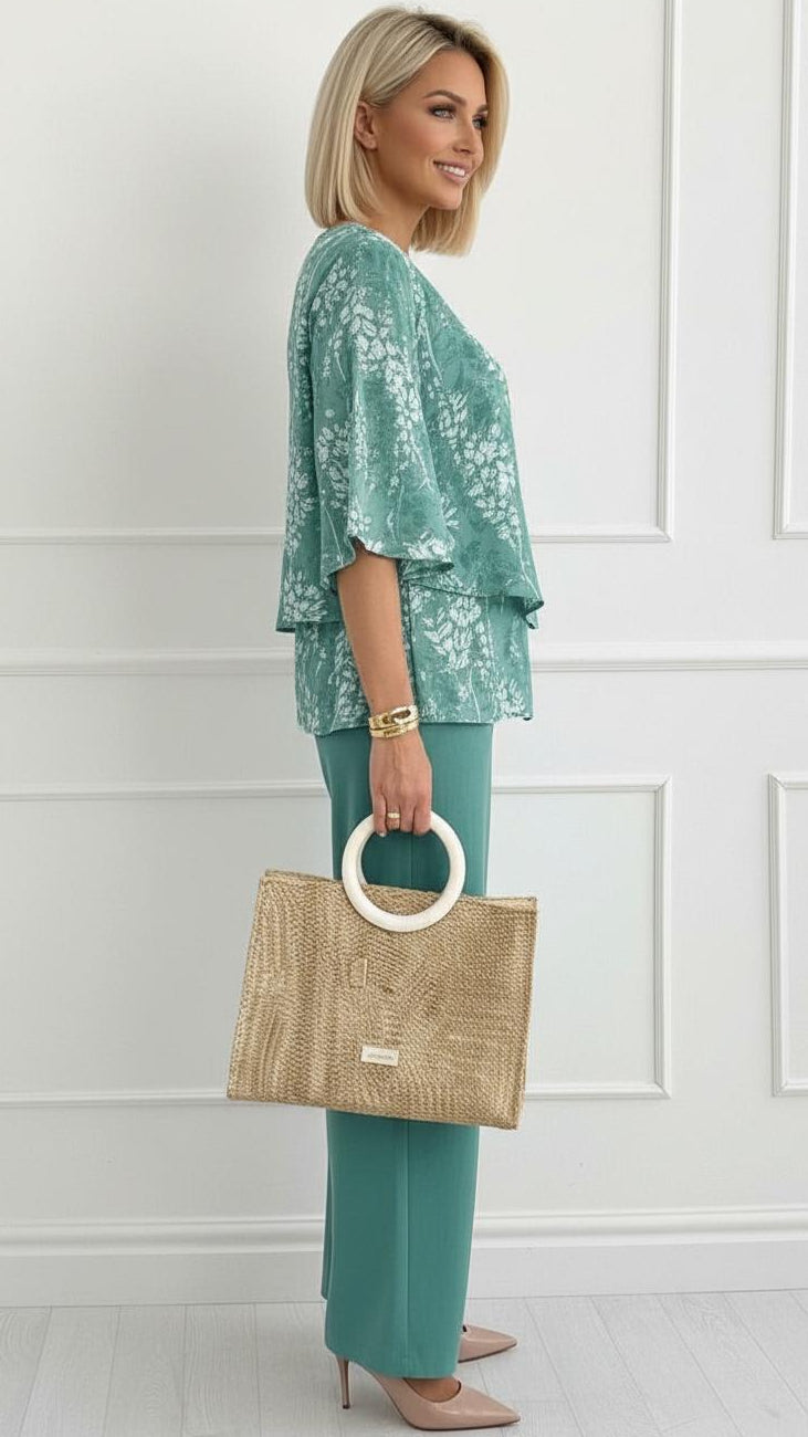 Close-up of the vibrant teal floral pattern on a comfortable women's summer two-piece outfit.