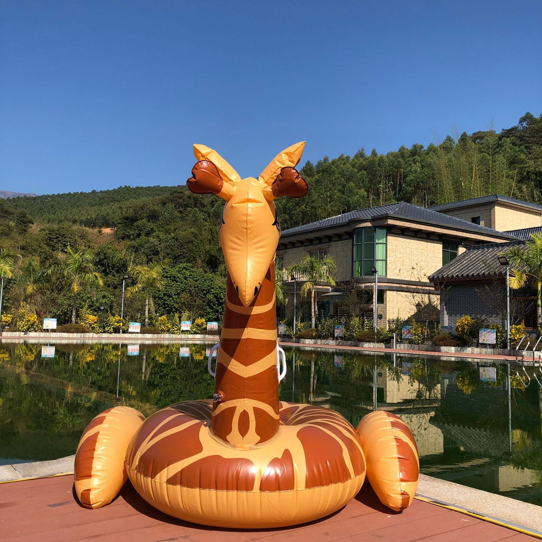 People relaxing on a huge inflatable giraffe pool float, bringing summer fun to any pool party or beach.