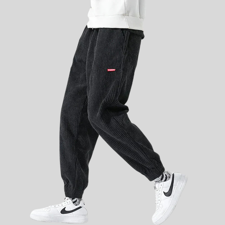 Black men's corduroy joggers, wide leg, offering ultimate comfort and a relaxed fit for casual style.