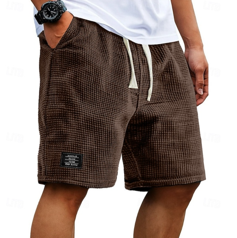 Man wearing grey relaxed fit casual summer shorts, paired with a t-shirt for a comfortable, breezy look.