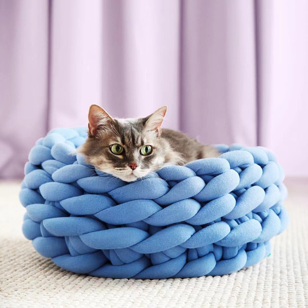 Grey, hand-knitted cat basket offering a warm and secure napping spot.