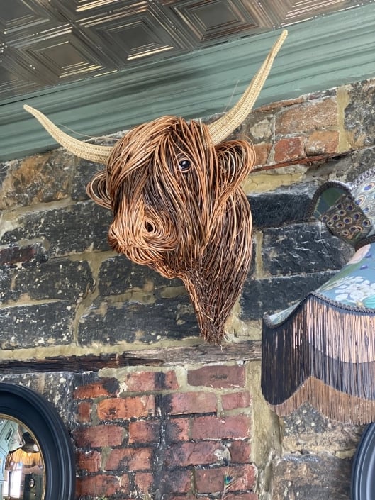 Handmade rattan Toro wall sculpture. Organic, natural fiber artwork adds rustic charm & boho elegance to walls.