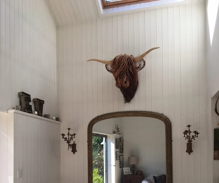 Boho wall decor: Hand-woven rattan Toro sculpture. Rustic, natural fiber art for a modern farmhouse aesthetic.