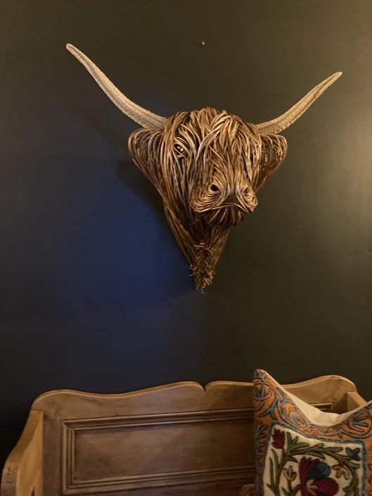 Intricate hand-woven rattan Toro sculpture. Rustic, natural fiber art decor enhances living rooms, bedrooms.