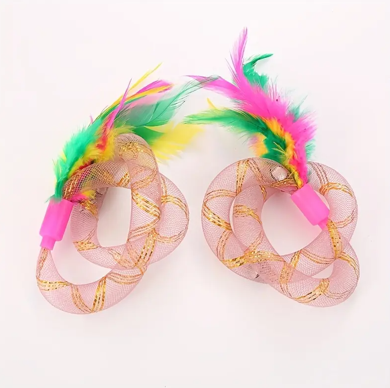 Happy cat pouncing on an interactive feather shuttlecock and mesh ring toy, promoting playful exercise.