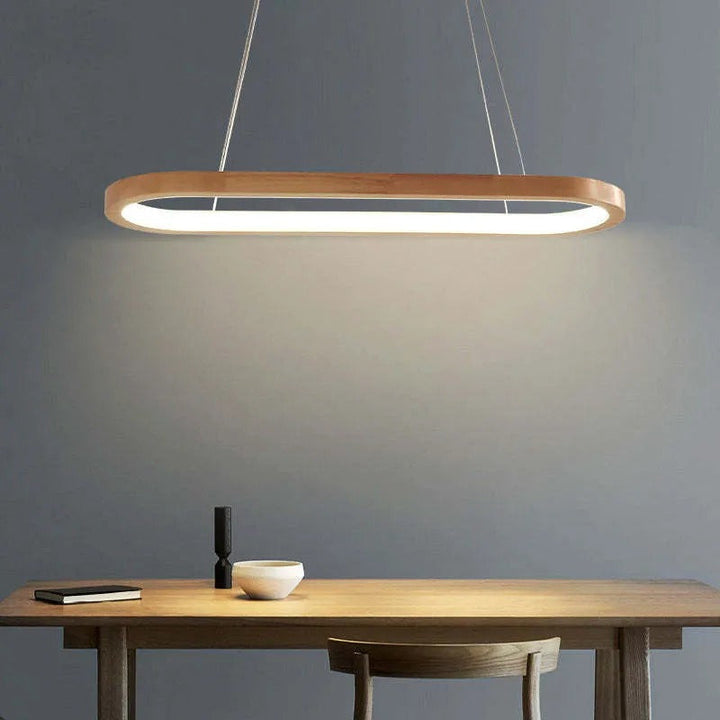 Modern wood and acrylic oval pendant light, providing warm LED lighting for dining areas.