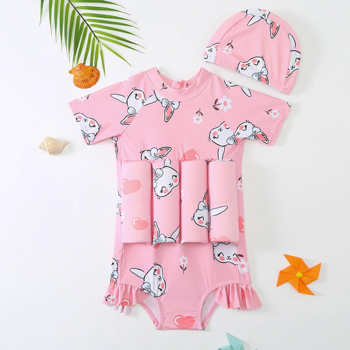 Child wearing a pink children's buoyancy vest, enjoying pool time safely.