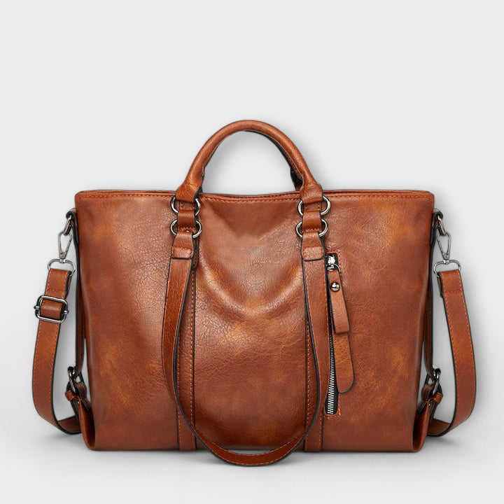 Large women's leather carryall tote bag with sturdy shoulder straps for daily use.