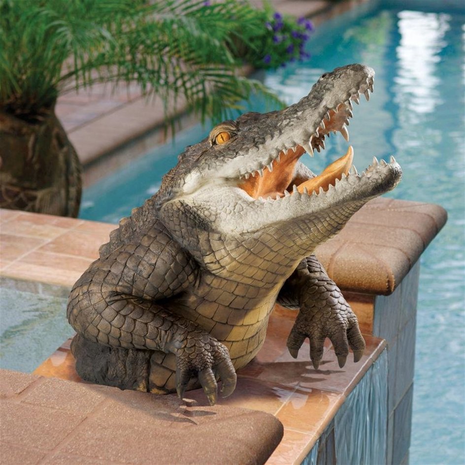 Resin crocodile statue (19-inch) blending into a lush garden, perfect lifelike outdoor animal art.