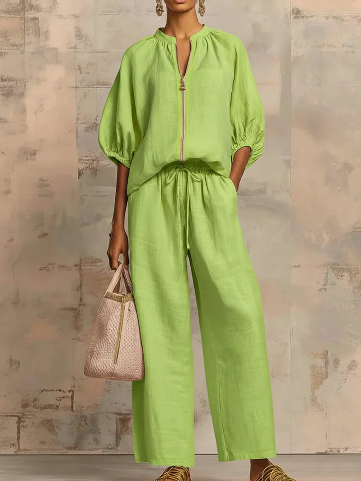 Black women's two-piece set featuring a relaxed fit button-up shirt and wide-leg trousers. Versatile casual chic.