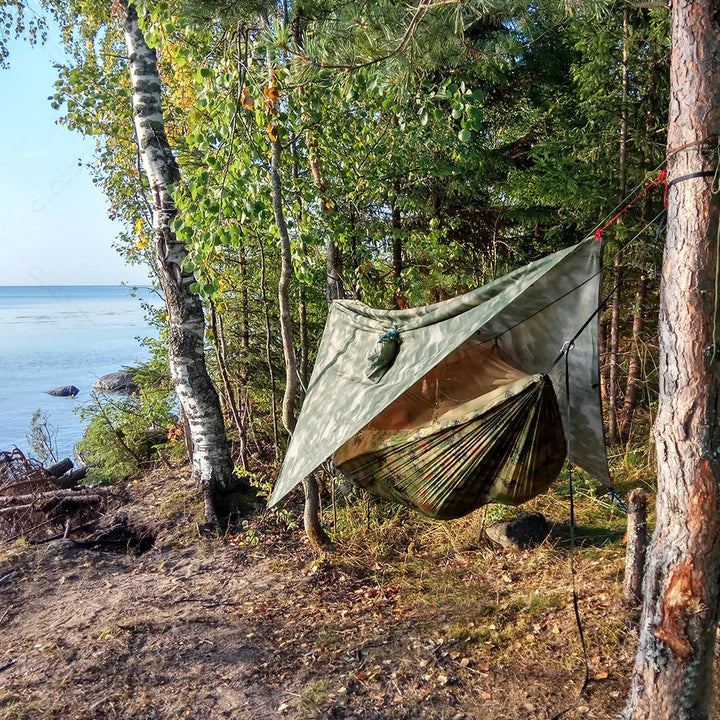 Comfortable camping hammock featuring a protective mosquito net and waterproof rain tarp.