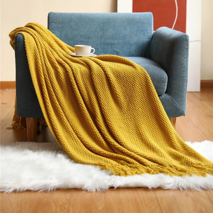 Stylish merino-style throw blanket with decorative tassels. Soft, warm, and luxurious for any home decor.