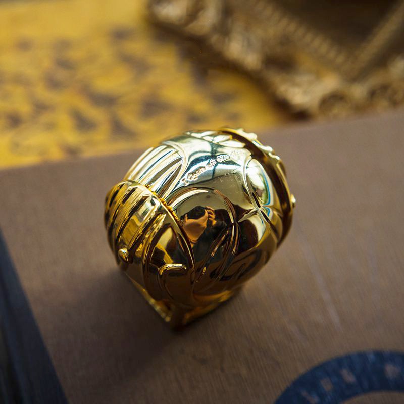 Movable fantasy jewelry case shaped like a golden winged orb.