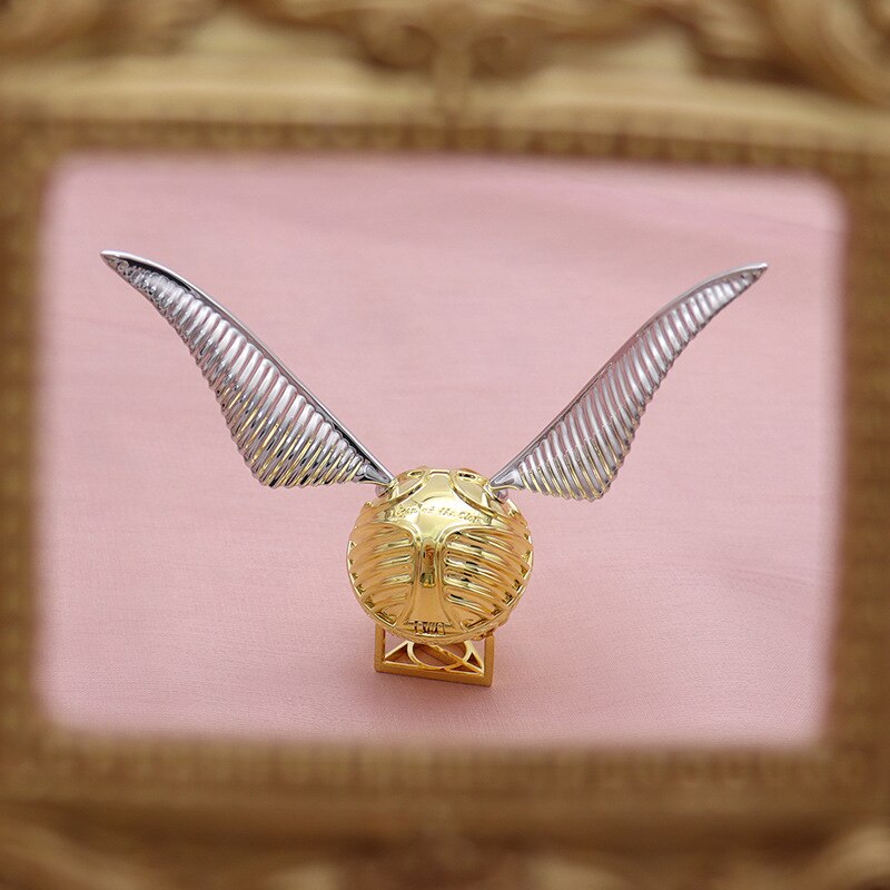 Open view of the luxury gold ring box with winged orb design.