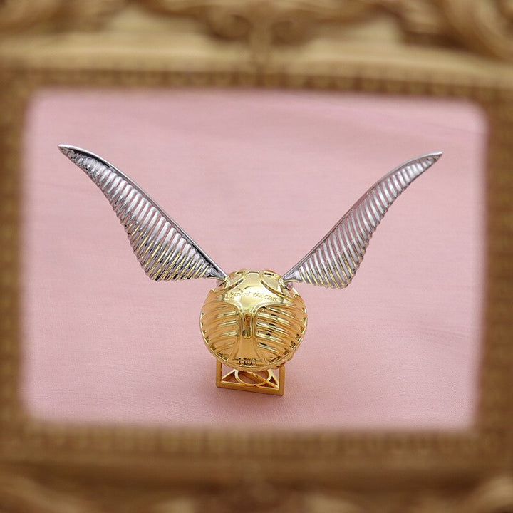 Open view of the luxury gold ring box with winged orb design.