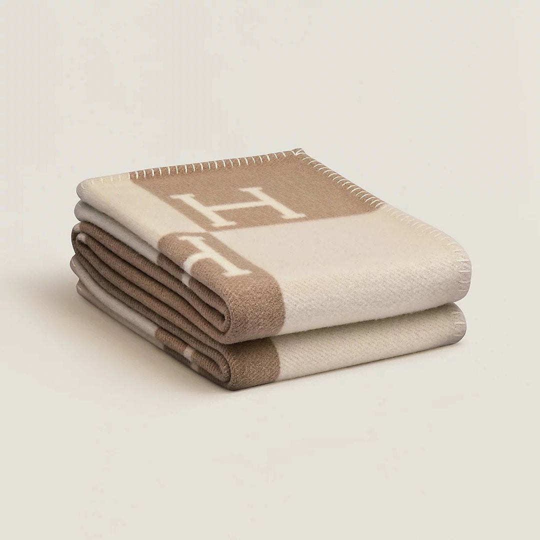 Elegant beige wool cashmere throw blanket draped over a sofa, adding cozy home decor