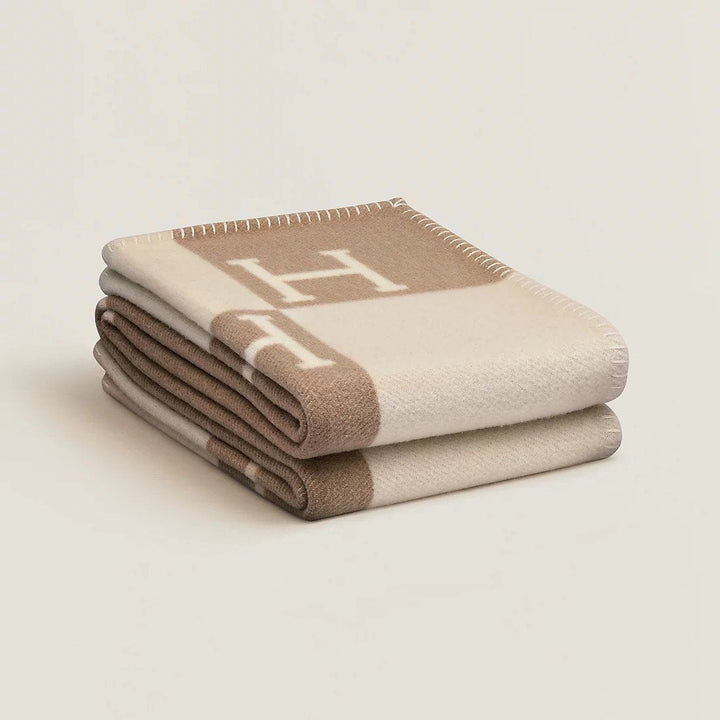 Elegant beige wool cashmere throw blanket draped over a sofa, adding cozy home decor