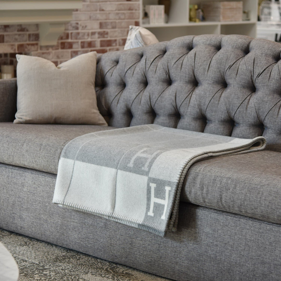The deep forest green wool cashmere throw blanket as a decorative throw on an armchair