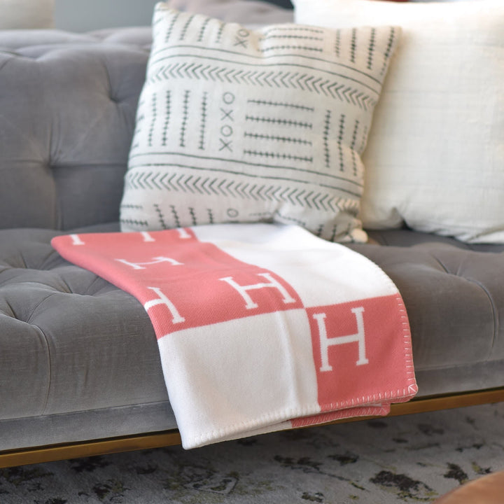 A cozy scene with a coffee mug and a warm, oversized wool cashmere throw blanket in a soft pink hue