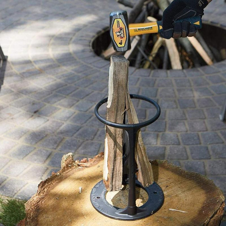 User safely splitting logs with a manual firewood tool in an outdoor setting.