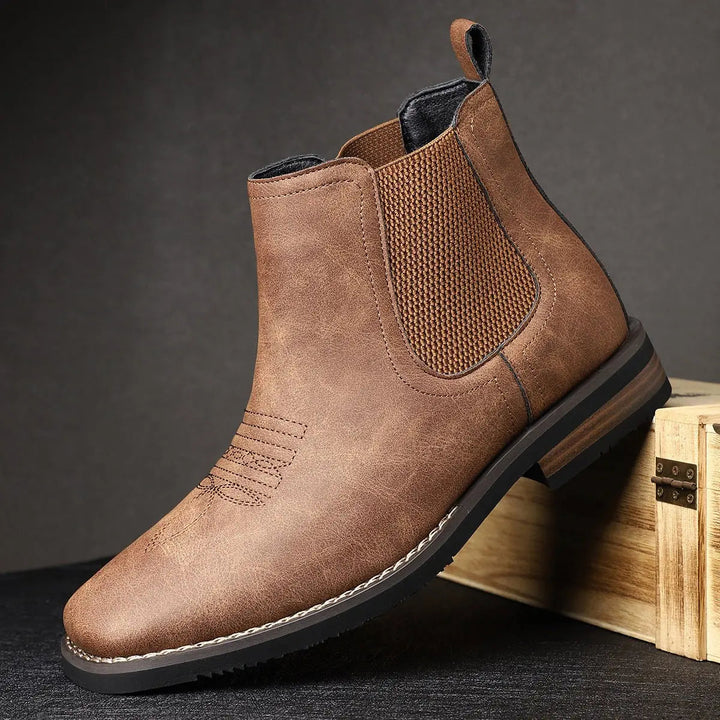 Men's black leather ankle boots, Chelsea style, showcasing detailed western stitching on the shaft.