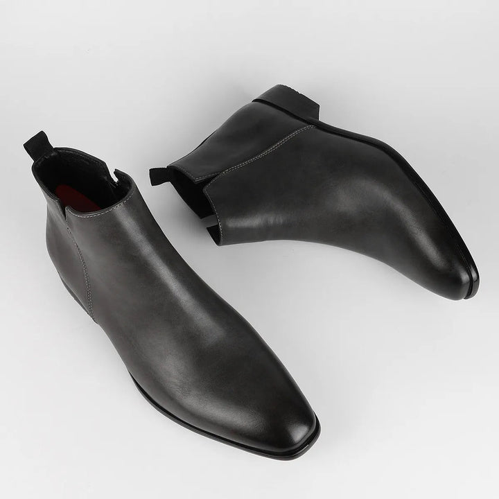 Close-up of side zipper on men's dark brown classic retro ankle boots, vintage look, durable.
