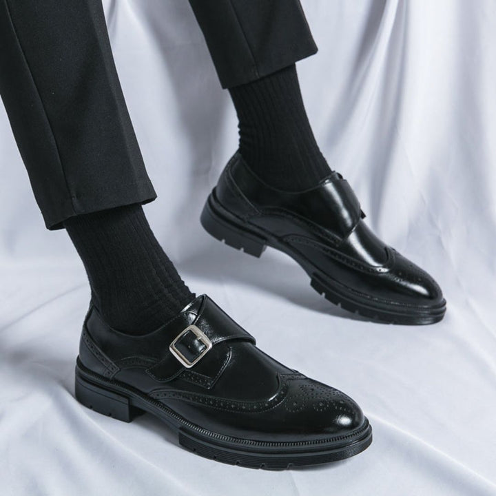 Business casual men's black dress shoes with classic monk strap and brogue detailing.